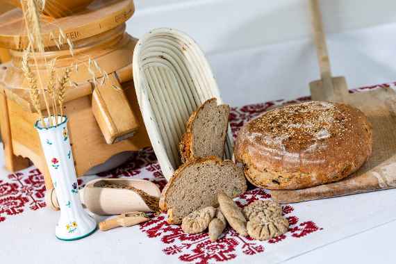 Brot und frisches Gebäck vor einer Getreidemühle