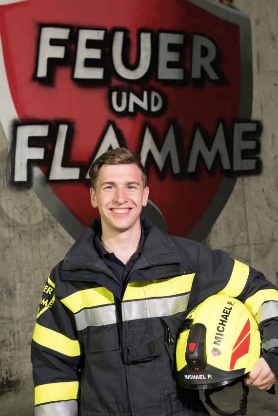 Michael Pickelsberger vor dem Logo der Serie "Feuer und Flamme"