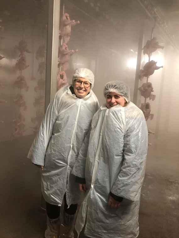 Zwei Schülerinnen in Hygieneanzügen im Kühlraum der Firma Wech