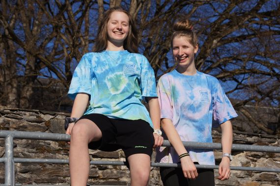 Zwei Schülerinnen präsentieren ihr gebatiktes Pitz T-Shirt in der Sonne