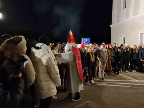 der Nikolo teilt den Schülern Süßigkeiten aus