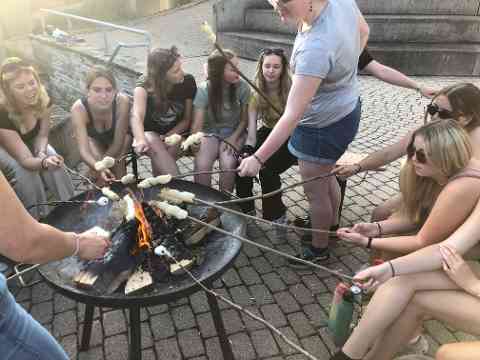 Schülerinnen sitzen am Lagerfeuer